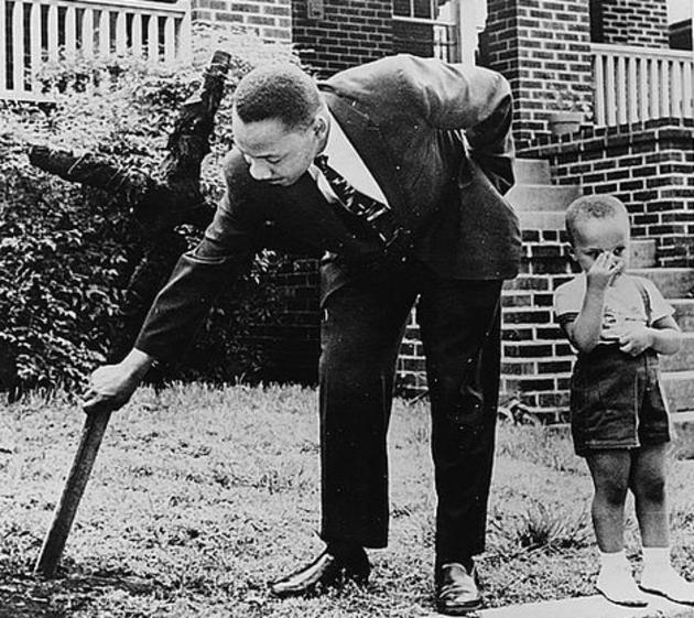 Martin Luther King retirando una cruz quemada en su jardín  junto a su hijo en 1960