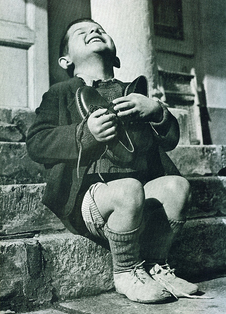 Un niño polaco feliz tras haber recibido un par de zapatos nuevos durante la Segunda Guerra Mundial.