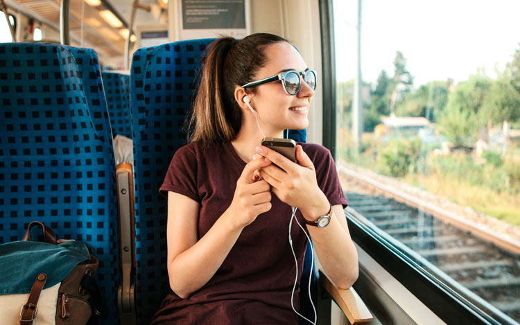 Chica escuchando podcast en el tren